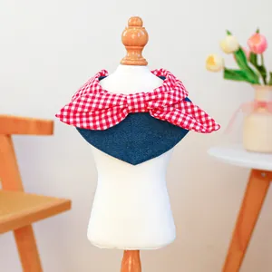 Detail of pet bandana featuring red gingham bow and navy denim fabric for small dogs