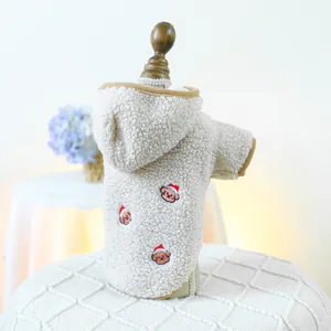 Detail of beige fleece dog hoodie featuring Christmas bear embroidery and soft texture