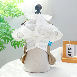 Détail d'une robe pour chien avec col en dentelle blanche et jupe plissée kaki sur mannequin
