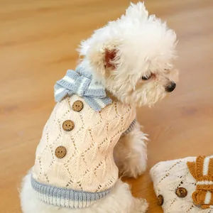 Detail of pet knit sweater showing wooden buttons, bow tie, and hollow out texture