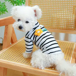 Detail of striped pet shirt with yellow flower and D-ring on a Bichon Frise