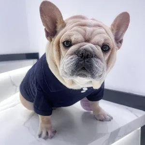 Gros plan d'un bouledogue français portant un polo en coton bleu marine à boutons blancs