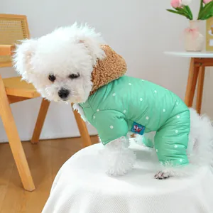Detail of mint green polka dot dog jumpsuit with warm brown fleece hood in cozy setting