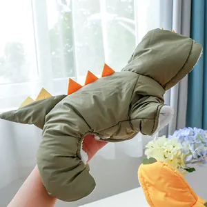Detail of army green dinosaur pet coat showing soft white fleece lining and orange spikes