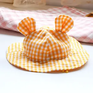 Close-up of yellow plaid pet sun hat with cute round ears and soft cotton texture