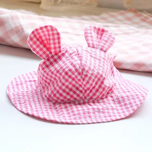 Macro detail of the pink plaid pattern and cute rabbit ears on this infant sun hat