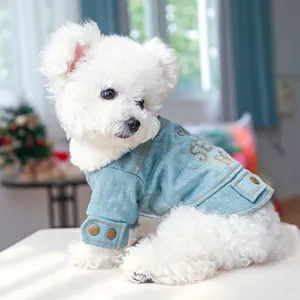 Detail einer hellblauen Hunde-Jeansjacke mit Kupferknöpfen und Stickerei-Akzenten