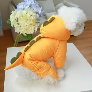Detail of yellow dinosaur themed pet hoodie with green fins on a white Bichon dog