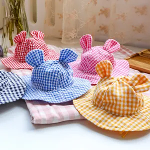 Close-up of colorful checkered pet sun hats with cute animal ears in various bright colors
