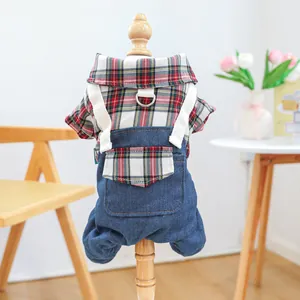 Detail of pet plaid shirt and denim overalls with a metal D-ring for leash attachment
