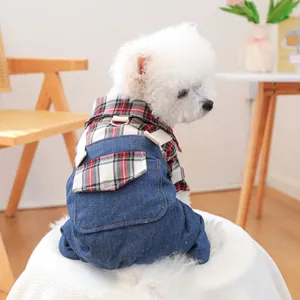 Detail of blue denim pet overalls with integrated harness D-ring and plaid shirt design