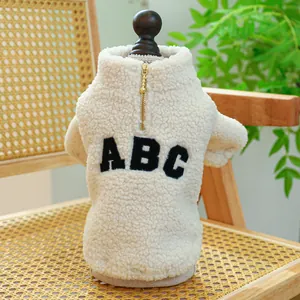 Close-up of warm sherpa pet coat featuring ABC embroidery and golden back zipper