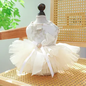 Close-up of elegant cream pet wedding dress with lace embroidery and pearl bow detail