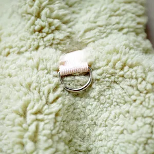 Detail of silver D-ring with pink strap on sage green sherpa fleece pet apparel