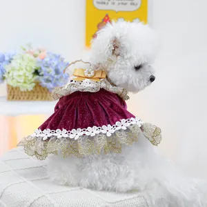 Detail of burgundy velvet pet dress with yellow bow, pearl accent, and lace trim