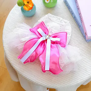 Detail of pink tutu pet dress featuring white lace, sequins, and a large satin bow