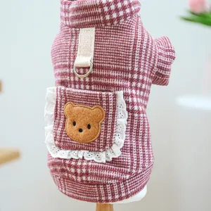 Detail von rotem Hunde-Karo-Pullover mit Spitzentasche und Bär-Stickerei