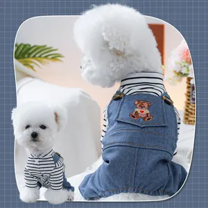 Dettaglio della salopette in jeans per cani con ricamo orso e maglia a righe manica lunga