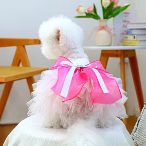 Close-up of pink layered mesh pet dress with large bow and glitter hearts on a small dog