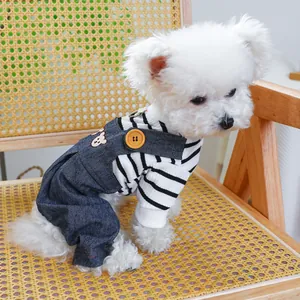 Close-up of pet denim overalls with bear embroidery and striped shirt on a small dog