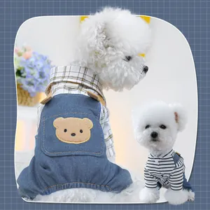 Dettaglio salopette in denim per cani con toppa a orsetto e camicia a quadretti in cotone
