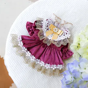 Detailed view of luxury pet dress with purple velvet, white lace trim and yellow bow