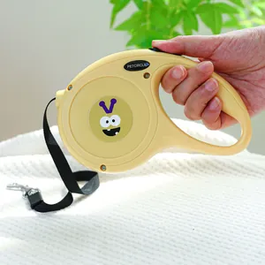 Détail de la laisse rétractable jaune pour chien avec motif dessin animé et poignée ergonomique