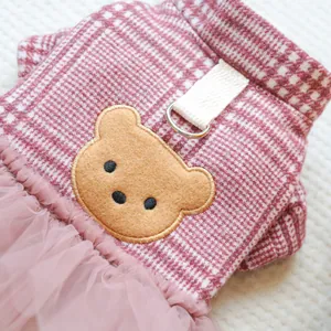 Detail eines rosa karierten Haustierkleides mit Teddybär-Stickerei und Metall-D-Ring-Haken