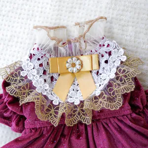 Detail of red velvet pet dress featuring white lace layers and a yellow satin bow