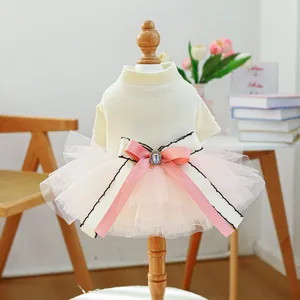 Detail of pet dress with a pink tulle skirt and a large bow with rhinestone on a wooden model