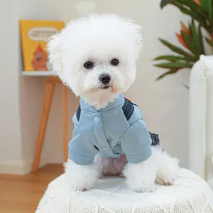 Gros plan d'un gilet bleu pour chien avec bretelles en jean sur un Bichon Frisé