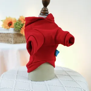 Detail of red pet hoodie featuring a ribbed cuff and blue side label on a soft cotton fabric