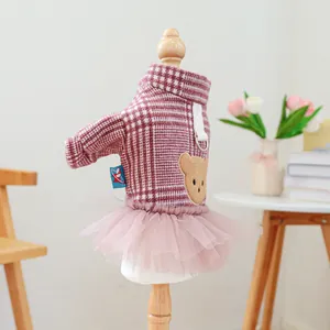 Detail eines rosa karierten Hundekleids mit Plüschbär-Aufnäher und Schichten aus Tüll