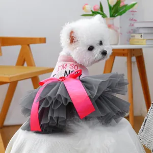 Close-up of a pink dog tutu dress featuring a satin bow and layered grey mesh skirt