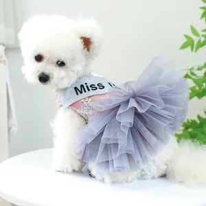Détail de robe rose en dentelle pour chien avec jupe en tulle gris et écharpe Miss