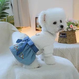 Dettaglio di un vestito per cani con ricamo floreale, gonna in denim e anello a D in metallo