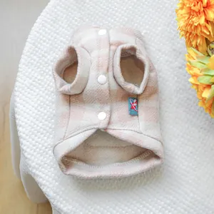 Details der warmen karierten Haustierweste mit weichem Fleece und weißen Druckknöpfen