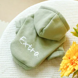 Detailed view of green pet hoodie with white Extra letter print on warm knit fabric