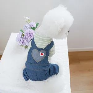 Détail d'une tenue pour chien avec chemise à rayures vertes et salopette en jean