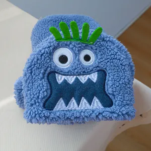 Gros plan sur un pull bleu en polaire pour chat avec broderie monstre et cheveux en feutre