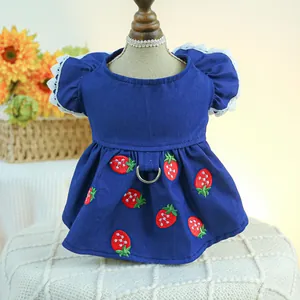 Détail de robe denim pour animaux avec broderie fraise et manches en dentelle blanche