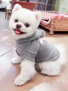 Detalle del suéter de punto gris para perros con estrella rosa y puños de canalé suaves