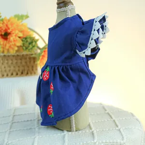 Détail d'une robe pour chien avec broderie fraise, dentelle blanche et boucle en D métal