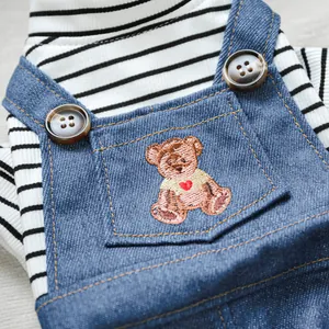 Détail du t-shirt rayé pour animaux avec salopette en jean et broderie d'ourson