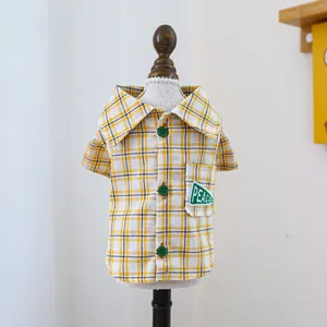 Detail der gelb karierten Haustier-Bluse mit Peace-Stickerei und drei Knöpfen