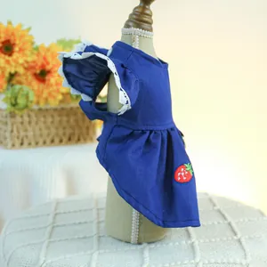 Détails de broderie fraise et dentelle blanche sur une robe en jean pour chien