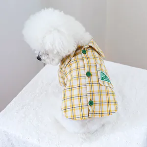 Detailaufnahme des gelb karierten Hundehemds mit grünen Knöpfen und Peace-Aufnäher
