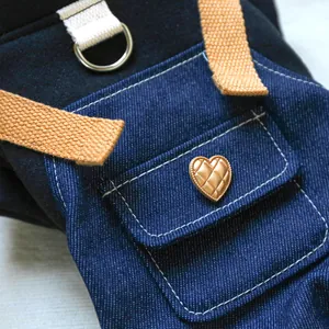 Détail d'une salopette en jean pour animaux avec bouton coeur doré et anneau en D en métal