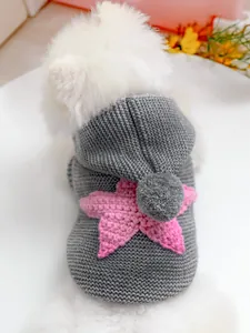 Detalle de suéter de punto gris para mascotas con estrella rosa y pompón en capucha