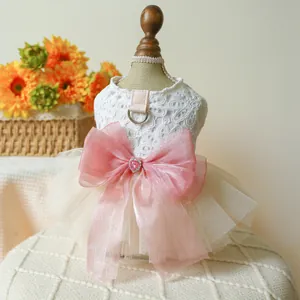 Detailed close-up of a lace pet dress featuring a large pink bow and metal D-ring attachment